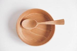 Empty wooden bowl and wooden spoon on a white table background. Top view. Copy, empty space for text photo