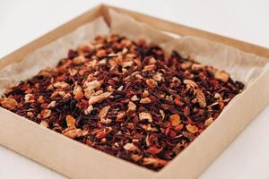 Dry fruit tea in a paper box on a white table background. Copy, empty space for text photo