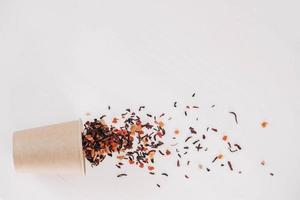 Dry fruit tea with disposable paper cup scattered on a white background. Top view. Copy, empty space for text photo