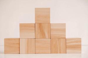 Pyramid of wooden blocks from natural wood on a white background. Copy, empty space for text photo