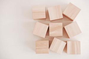 Wooden cubes from natural wood on a white background. Top view. Copy, empty space for text photo
