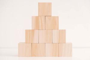 Pyramid of wooden blocks from natural wood on a white background. Copy, empty space for text photo