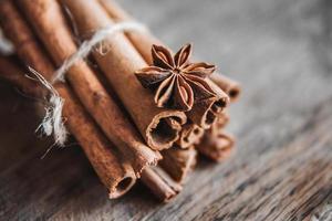 palitos de canela y estrella de anís sobre un fondo de madera foto