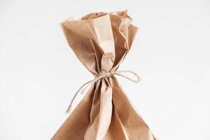 Disposable bag of brown kraft paper on a white background. Copy, empty space for text photo