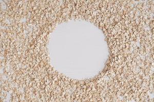 Dry oatmeal scattered in the form of a circle on a white background. Top view. Copy, empty space for text photo