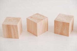 Three wooden blocks from natural wood on a white background. Copy, empty space for text photo