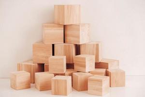 Pyramid of wooden blocks from natural wood on a white background. Copy, empty space for text photo