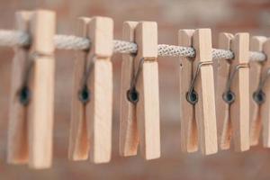 Wooden clothespins on a rope. Selective focus on one clothespin photo