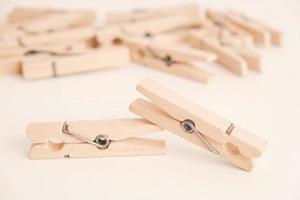 Many wooden clothespins on a white table background. Housework concept. Copy, empty space for text photo