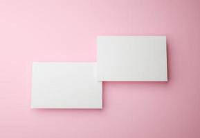 procesamiento 3d maqueta de dos tarjetas de visita sobre fondo rosa. concepto de identidad comercial y de marca foto