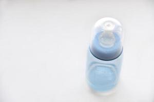 Blue baby bottle with a pacifier for water photo