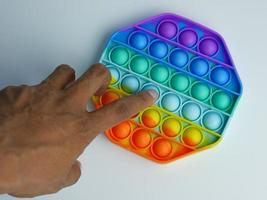 hand playing hexagon pop it fidget toy. isolated on a white background. anti stress therapy game photo