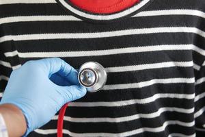 Doctor using a stethoscope checking body, close up photo