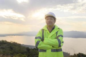 a man engineer is putting a protective helmet on her head at sunset. photo