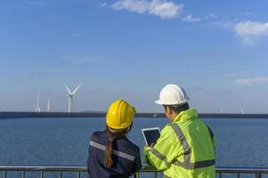 people engineer are wearing a protective helmet on head, using tablet Analytics engineering data. photo