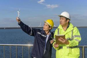 people engineer are wearing a protective helmet on head, using tablet Analytics engineering data. photo