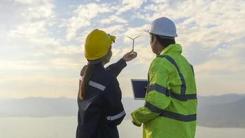 el ingeniero de personas lleva un casco protector en la cabeza, utilizando datos de ingeniería de análisis de tabletas. foto