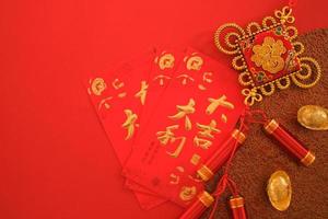 Chinese New Year festival concept. Red envelopes, and gold ingots on red background. Chinese character da ji da li meaning great luck great profit and fu which stands for luck.. photo