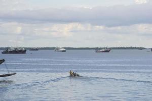 sorong, papúa occidental, indonesia, 30 de septiembre de 2021. los aldeanos cruzan las aguas de sorong usando botes foto