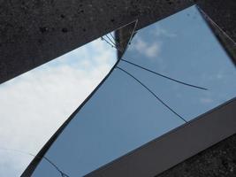 blue sky with clouds reflected on broken mirror photo