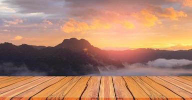 Natural wood floor mountain view background fog and sunset photo