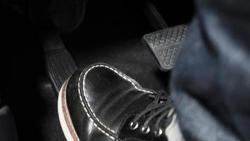 Close up the foot pressing foot pedal of a car to drive ahead. photo