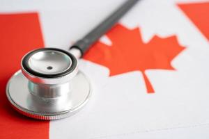 Black stethoscope on Canada flag background, Business and finance concept. photo