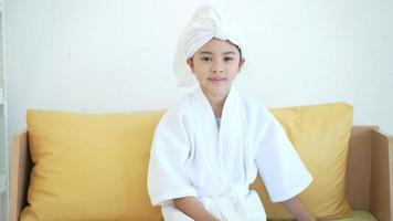 porträt eines glücklichen asiatischen mädchens im weißen bademantel zu hause, familie und schönheitskonzept video