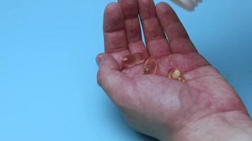 vitaminas ômega 3 derramadas na palma da mão. segure vitaminas em suas mãos. aceitar ômega 3 natural em cápsulas amarelas claras. estilo de vida saudável. o médico receitou os comprimidos.