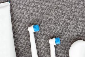 Toothpaste, toothbrush, dental floss on a gray background. Dental hygiene. photo