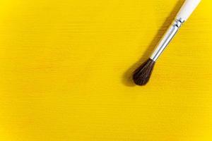 Brush on yellow textured background close-up photo