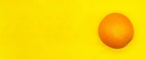 juicy ripe orange isolated on a yellow background close up with a blank space for your text photo