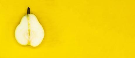 juicy pear cut isolated on a yellow background close up with a blank space for your text photo