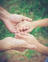 primer plano del padre sosteniendo la mano de su hija, tan dulce, tiempo en familia. foto