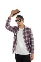 Portrait of young hipster man adjusting hat with head at camera on isolated over white studio background. photo