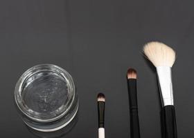 Various luxury makeup products on dark background, flat styling. photo