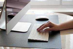 trabajar en casa. escribiendo en el teclado. trabajando en la computadora de forma remota de una niña. foto