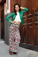 Young brunette woman smiling in urban background. photo