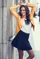 Young brunette woman smiling in urban background. photo