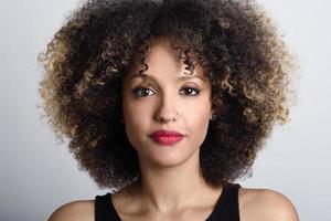 Young black woman with afro hairstyle on white background photo