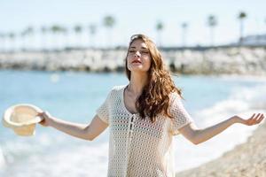 mujer con los brazos abiertos respirando profundamente en la playa. foto