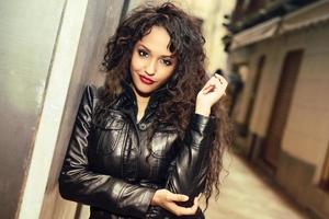 Attractive black woman in urban background wearing leather jacket photo