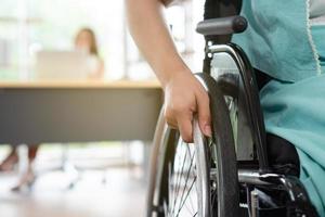 Woman With Disability Sitting in Wheelchair and Working in Office photo