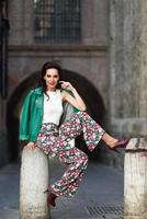 Young brunette woman smiling in urban background. photo