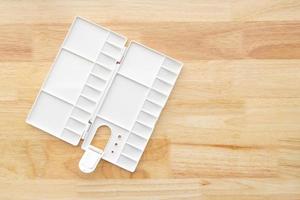 White watercolor palette. Empty watercolor tray isolated on wood background. photo