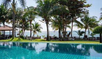 Part of swimming pool with background of tropical sea. photo