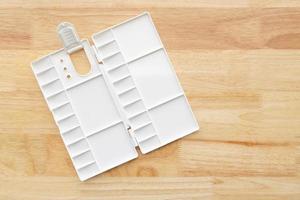 White watercolor palette. Empty watercolor tray isolated on wood background. photo