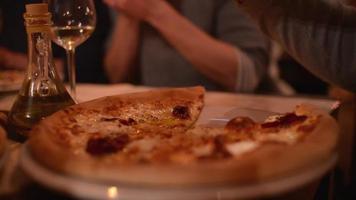 pessoas comendo pizza em um restaurante, grande empresa na mesa video