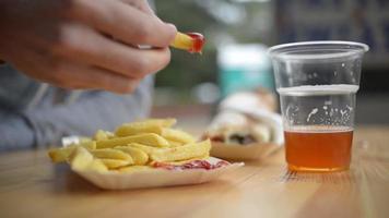 primer plano comiendo papas fritas con salsa de tomate en la mesa del café de comida callejera video