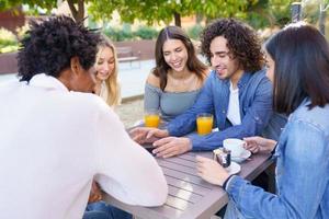 grupo de amigos diversos relajándose en un café callejero foto